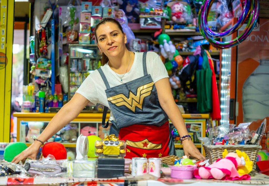 A woman in a wonder woman costume stands behind a counter